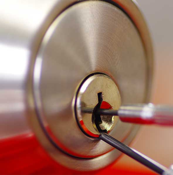 ALS Closeup hands of locksmith using metal pick tools to open locked door