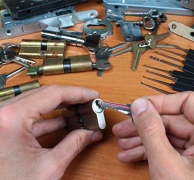 ALS Locksmith inserts key in cylinder lock