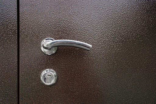 ALS - A metallic keyhole with knob on a brown metal door